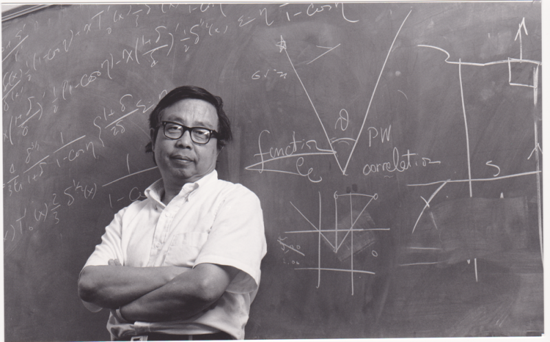 photo of Fang Lizhi standing in front of a chalkboard with equations