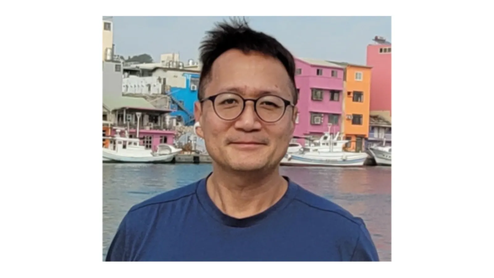 an image of the author dominic yang, a middle aged man with short black hair and glasses