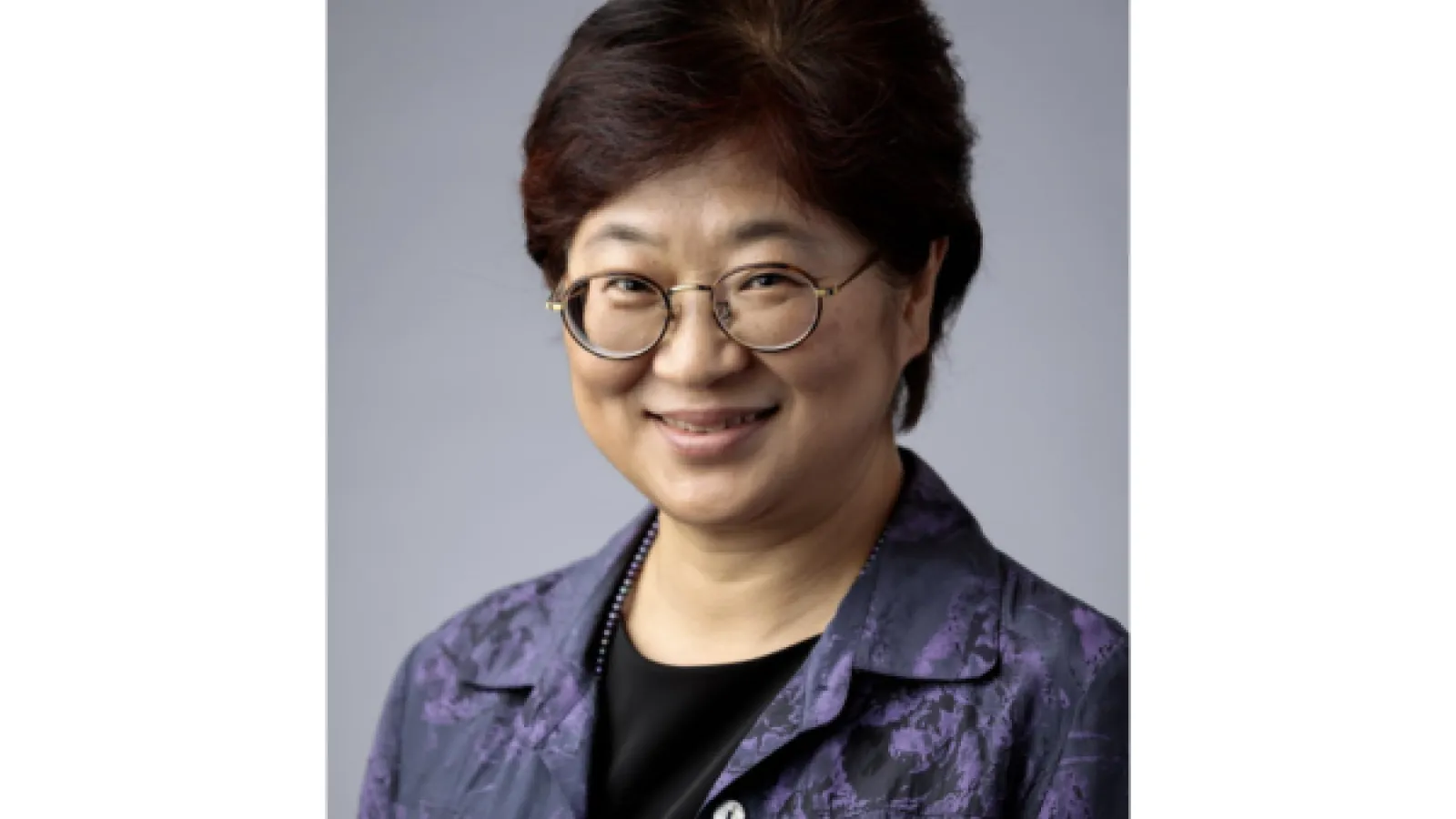 a middle aged woman with short black hair and glasses