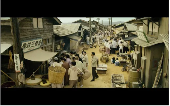 people gather around a radio in a narrow street