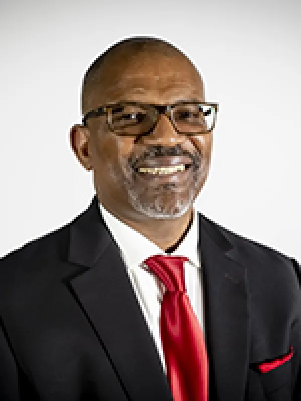 Picture of an older man with glasses in a suit 